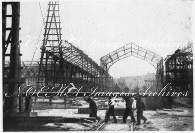 Au Champ-de-Mars.- Charpentiers apportant des pièces de l'échafaudage du Palais de l'électricité.1900年博 シャン・ド・マルス会場 － 電気館建設用足場の部分を運ぶ大工たち